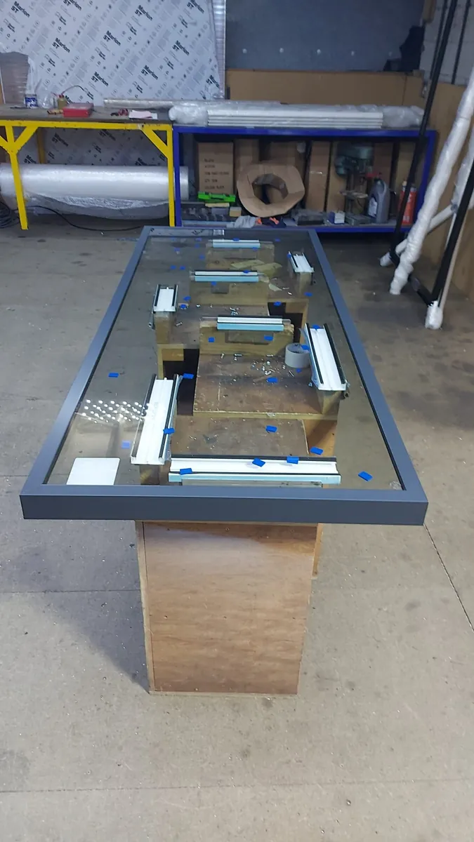 Glazed rooflight in a dark grey frame on the bench in the New Conservatory Roofs workshop